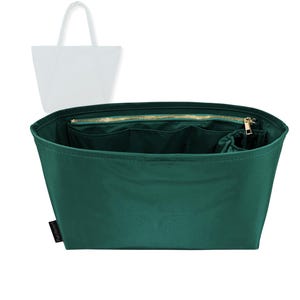 Op de afbeelding: Een donkergroene organizer voor een draagtas met meerdere compartimenten en een gouden rits. De organizer is ontworpen om in een grotere draagtas te passen, met een wit silhouet van een draagtas op de achtergrond.