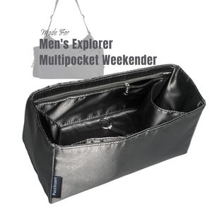 Può includere: Organizzatore per borsa grigio scuro, effetto satinato, con più tasche e uno scomparto con cerniera. Il testo "Made For Men's Explorer Multipocket Weekender" è visibile. L'organizzatore ha un portachiavi e il marchio "Purzinzert" è stampato sul lato.