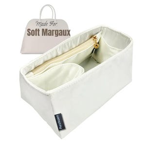Puede incluir: Organizador de bolso blanco con múltiples compartimentos y un bolsillo con cremallera. El organizador tiene forma rectangular y está hecho de un material suave. El texto "Made For Soft Margaux" es visible en el fondo.