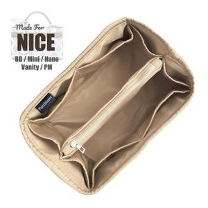Puede incluir: Organizador de bolso beige con múltiples compartimentos y una sección central con cremallera. El organizador está diseñado para adaptarse a modelos de bolsos específicos, como indica el texto "Made For NICE" y "BB / Mini / Nano Vanity / PM".