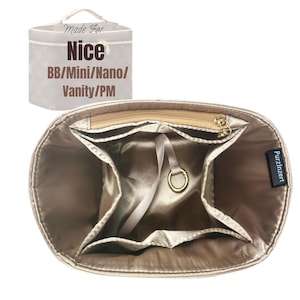 May include: Beige handbag organizer with multiple compartments and a zippered top. Features a gold-colored zipper and a small, attached ring. The text "Made For Nice BB/Mini/Nano/Vanity/PM" is visible.
