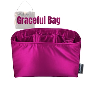 Puede incluir: Un organizador de bolso magenta con múltiples compartimentos. El organizador está diseñado para caber dentro de un bolso. El texto "Made For Graceful Bag" es visible en la imagen. Una pequeña etiqueta con el texto "Purzinzert" es visible.