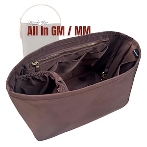 May include: A brown handbag organiser with multiple pockets and a zipped closure. The organiser is designed to fit inside a larger handbag. The text "Made For All In GM / MM" is visible in the image.