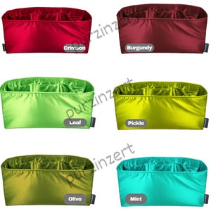 May include: A collection of colorful bag organizers in various shades, including crimson, burgundy, leaf green, pickle green, olive, and mint. Each organizer has multiple compartments for storage and organization.