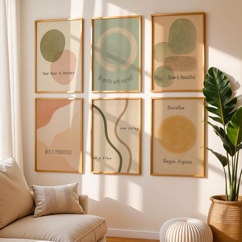 May include: Six framed art prints with gold frames. Each print features abstract shapes in muted colors like peach, olive green, and beige. The prints have inspirational text such as "Your Pace Is Perfect" and "Breathe. Begin Again."