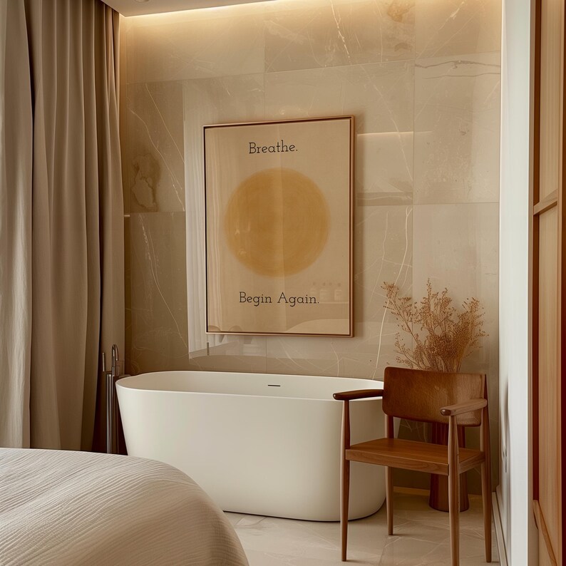 May include: A modern bathroom scene featuring a white freestanding bathtub, a wooden chair, and a framed art print. The art print has the words "Breathe. Begin Again." and a yellow circle. Beige curtains and tile complete the spa-like aesthetic.