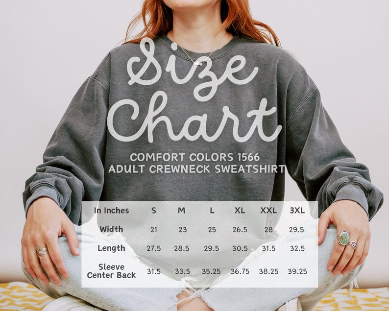 May include: Size chart for adult crewneck sweatshirts in Comfort Colors 1566. The chart shows measurements in inches for width, length, sleeve, and center back. Sizes range from S to 3XL.