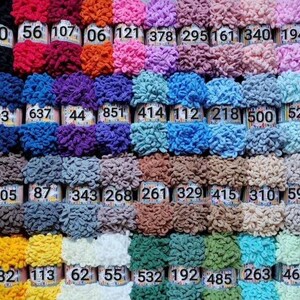 May include: A collection of 40 colorful yarn skeins in various shades of red, pink, blue, green, yellow, orange, purple, brown, and white. Each skein is labeled with a number.