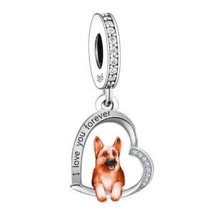 以下が含まれることがあります： ハート型のデザインのシルバーチャーム。中にジャーマンシェパードの犬がいます。ハートには「I love you forever」という文字が刻まれています。チャームの上にはクリアなクリスタルが飾られています。
