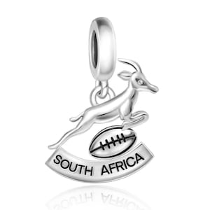 May include: Silver charm featuring a springbok antelope jumping over a rugby ball with the words "South Africa" on a banner below.