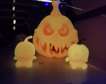 May include: Three glowing, 3D printed, Halloween jack-o'-lantern figures. The largest jack-o'-lantern has a scary, toothy grin and dripping eyes. The two smaller jack-o'-lanterns have a more friendly, smiling expression.