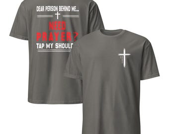 Puede incluir: Dos camisetas grises. La parte delantera de una camiseta tiene el texto "Querida persona detrás de mí... + ¿Necesitas oración? Toca mi hombro." La parte trasera de la otra camiseta tiene una cruz blanca.