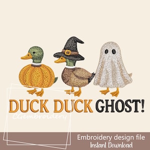 May include: An embroidery design featuring three ducks in Halloween costumes. One duck is dressed as a pumpkin, another as a witch, and the third as a ghost. The text "DUCK DUCK GHOST!" is displayed below the ducks.