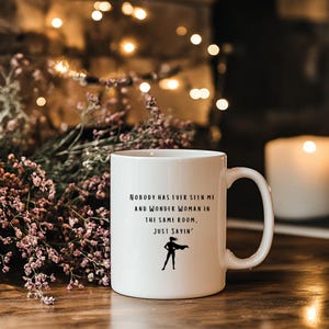 May include: White ceramic mug with a black silhouette of Wonder Woman and the text "Nobody has ever seen me and Wonder Woman in the same room. Just sayin'"