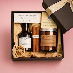 May include: A gift box with a black exterior, containing fragrance oil, a candle, face soap, cinnamon sticks, and a dried orange slice. The box includes a card that reads "Timeless scents for your most precious moments."