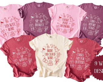 以下が含まれることがあります： ワインをテーマにしたTシャツの9つの異なるデザイン。Tシャツはピンク、赤、クリームなど、さまざまな色があります。各Tシャツには、「Yes Way, Rose」、「Sip, Sip, Hooray」、「I Make Pour Decisions」、「Vino Before Vows」、「You Can't Sip With Us」、「Bride on Cloud Wine」、「Corks Are For Quitters」など、ワインに関連するさまざまな言葉が書かれています。