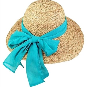 May include: A woven straw sun hat with a wide brim and a turquoise blue ribbon tied in a bow. The hat has a rounded crown and a wide brim, perfect for sun protection. The turquoise ribbon adds a pop of color and a decorative element.