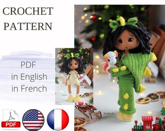 May include: Crochet pattern PDF in English and French for a doll wearing a green dinosaur costume and holding a white unicorn. The doll has brown skin and black hair.