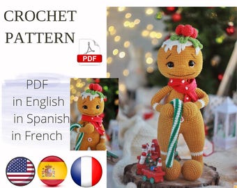 Puede incluir: Muñeco de hombre de jengibre tejido a ganchillo con bufanda roja y bastón de caramelo. El muñeco tiene un diseño de glaseado blanco en la cabeza y una baya roja. La imagen incluye texto: "CROCHET PATTERN" y "PDF en inglés, español, francés."