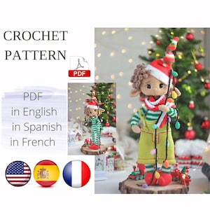 Puede incluir: Patrón de crochet PDF para un muñeco de elfo navideño con cabello castaño, que lleva un atuendo a rayas verde y blanco, un gorro rojo y sostiene una cadena de luces. El patrón está disponible en inglés, español y francés.