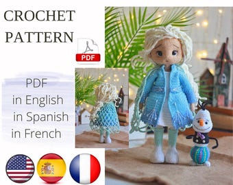 May include: Crochet pattern PDF in English, Spanish, and French for a blue and white crocheted doll with blonde hair and a blue crocheted coat. The doll is holding a small crocheted snowman.