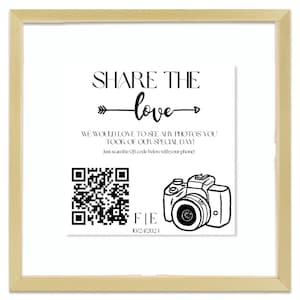 May include: A framed print with the words "SHARE THE love" and a QR code. Below the text is a drawing of a camera. The date "10/24/2021" is printed below the camera illustration.