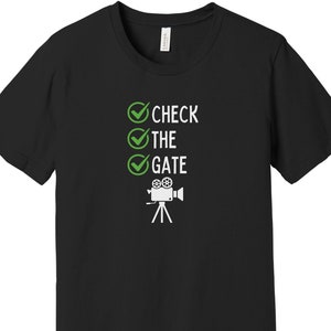 May include: Black t-shirt with a white graphic of a film camera and the text "CHECK THE GATE" with green tick marks.