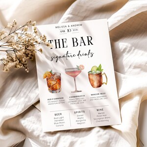 以下が含まれることがあります： 「The Bar Signature Drinks」と黒文字で書かれた白い看板。看板には、オールドファッション、コスモポリタン、モスクワミュール、ビールの4種類のカクテルのイラストが描かれている。また、各カクテルの材料と、ビール、スピリッツ、ワインのセレクションも記載されている。
