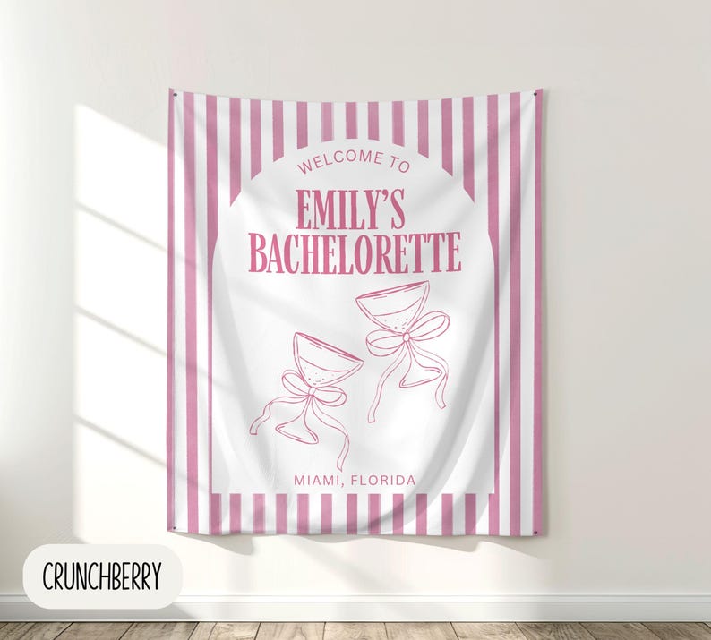 Puede incluir: Un tapiz a rayas rosas y blancas con el texto "Welcome to Emily's Bachelorette" y dos copas de champ&aacute;n con lazos. Tambi&eacute;n se incluye el texto "Miami, Florida".