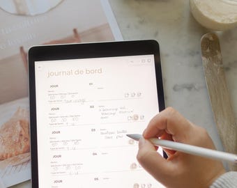 May include: A digital tablet with a white stylus on the screen. The screen displays a journal with the title "journal de bord" and a list of days with handwritten notes. The tablet is on a white marble surface.