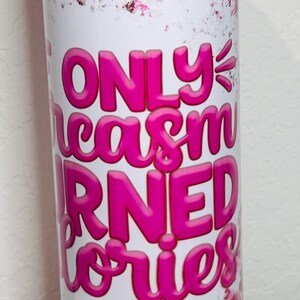 May include: Pink and white stainless steel tumbler with a leopard print design and the text "Only sarcasm earned stories".