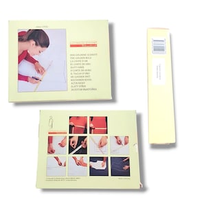 May include: A Lutterloh System International sewing pattern kit featuring a light yellow box with instructional imagery of a person using a measuring tool on fabric, alongside a tall, narrow yellow box with a barcode and safety warning text.