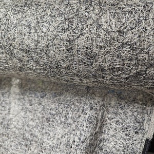 May include: Close-up of a white and black mesh fabric. The fabric has a woven texture and is made of thin, criss-crossed threads.