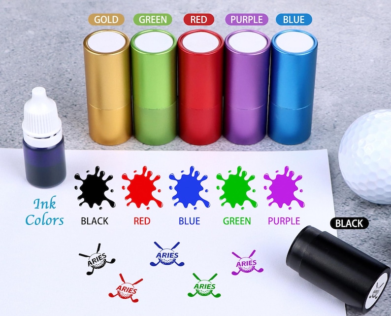 May include: A selection of golf-themed ink stamps in gold, green, red, purple, and blue, with corresponding ink blotches. An ink bottle and a golf ball are also visible. The word "Aries" is printed on the stamps.