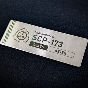 May include: A silver metal sign with the text "CONTAINMENT CELL SCP-173 CLASS KETER" and a stylized symbol of a circle with three arrows.