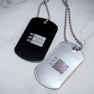 K&ouml;nnte beinhalten: Zwei silberne Hundemarken mit einer Kette. Die obere Marke ist schwarz und die untere Marke ist silber. Beide Marken haben den Text "WE SECURE. WE CONTAIN. WE PROTECT." aufgedruckt.