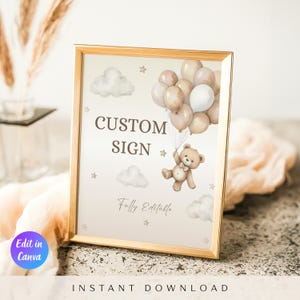 Puede incluir: Un letrero enmarcado con borde dorado presenta un oso de peluche sosteniendo globos. El letrero dice "CUSTOM SIGN" y "Fully Editable" en una paleta de colores suaves y neutros. Nubes y estrellas decoran el fondo. Las palabras "Edit in Canva" están en un círculo morado.
