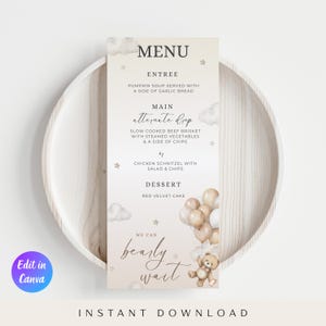 Puede incluir: Una tarjeta de menú para baby shower con fondo beige claro. El menú ofrece entrantes, platos principales y postres. El diseño incorpora ositos de peluche, globos e ilustraciones de nubes. También se incluye el texto "We can bearly wait".