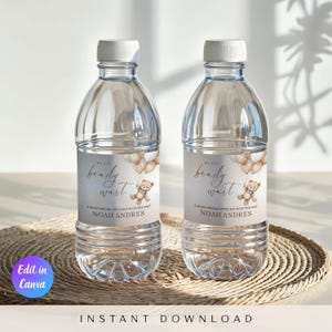 以下が含まれることがあります： 白いキャップが付いた透明なプラスチック製のウォーターボトルが2本。各ボトルには「We can bearly wait」の文字とテディベアのグラフィックが描かれたラベルが付いています。「A beary special little boy is on the way」の文字と「Noah Andres」の名前もラベルに記載されています。