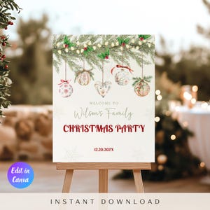 May include: A white Christmas party welcome sign on a wooden easel. The sign displays the text "Welcome to Wilson's Family Christmas Party" in red and script font, with festive ornaments and foliage. The date 12.20.202X is also shown.