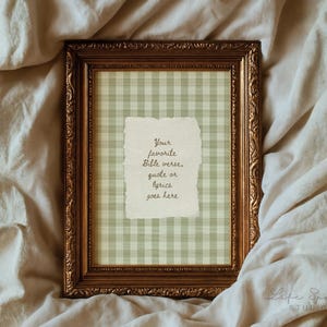 May include: A rectangular picture frame with an ornate metallic gold finish containing a light green and white gingham patterned background and a central torn-edge paper insert with the text: Your favourite Bible verse, quote or lyrics goes here.