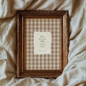 May include: A framed print with a gold-colored ornate frame. The print features a tan and white checkered pattern background with a torn paper-like element in the center. The text on the paper reads "Your favorite Bible verse here."