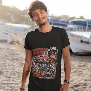 May include: A black t-shirt with a graphic print of a cartoon character driving a red car. The text "Surfing Street" is printed on the shirt.