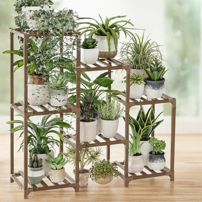May include: A brown, multi-tiered plant stand filled with various potted plants. The stand has a square frame with slatted shelves, showcasing a variety of green foliage and decorative pots. The arrangement creates a layered display of indoor plants.