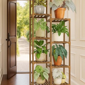 Pu&ograve; includere: Un portapiante in legno con pi&ugrave; ripiani, che espone varie piante in vaso. Il portapiante &egrave; realizzato in legno marrone chiaro e si trova vicino a una porta aperta. Le piante hanno un fogliame verde e sono in vasi di diversi colori.
