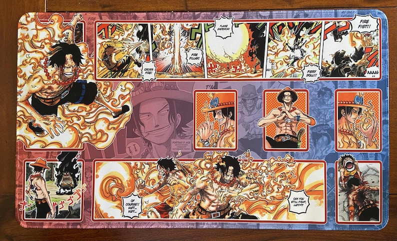 May include: A rectangular playmat featuring a colorful manga-style illustration. The design showcases a character surrounded by flames, with panels of action scenes and text bubbles. The color palette includes red, orange, and blue.