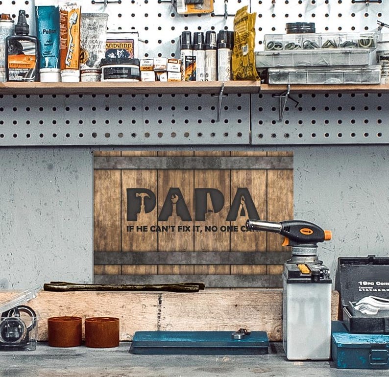 Each letter in the bold word PAPA includes the silhouette of a hand tool as part of the letter.  Beneath the word PAPA is the phrase “If he can’t fix it, no one can.” The background looks like aged vertical boards similar to a flattened oak barrel. At the top and bottom are aged metal strips. This is a perfect gift for anyone’s husband, dad, stepdad, grandpa, or favorite male friend who has tools and knows who to fix things. NOTE: This is a flat metal sign, not real wood or metal.