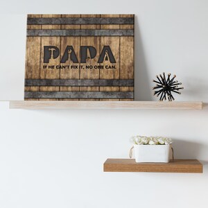Each letter in the bold word PAPA includes the silhouette of a hand tool as part of the letter.  Beneath the word PAPA is the phrase “If he can’t fix it, no one can.” The background looks like aged vertical boards similar to a flattened oak barrel. At the top and bottom are aged metal strips. This is a perfect gift for anyone’s husband, dad, stepdad, grandpa, or favorite male friend who has tools and knows who to fix things. NOTE: This is a flat metal sign, not real wood or metal.