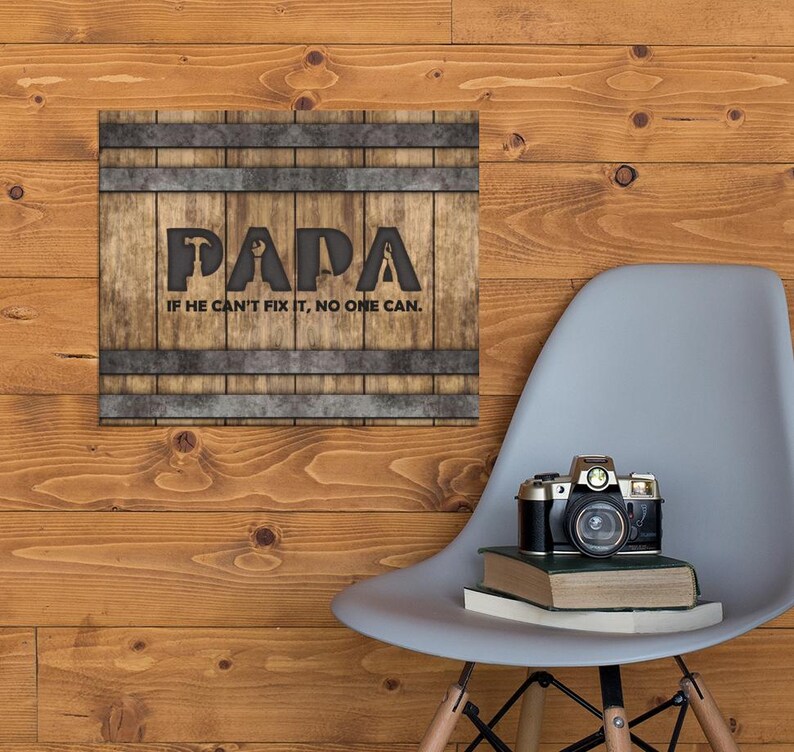 Each letter in the bold word PAPA includes the silhouette of a hand tool as part of the letter.  Beneath the word PAPA is the phrase “If he can’t fix it, no one can.” The background looks like aged vertical boards similar to a flattened oak barrel. At the top and bottom are aged metal strips. This is a perfect gift for anyone’s husband, dad, stepdad, grandpa, or favorite male friend who has tools and knows who to fix things. NOTE: This is a flat metal sign, not real wood or metal.