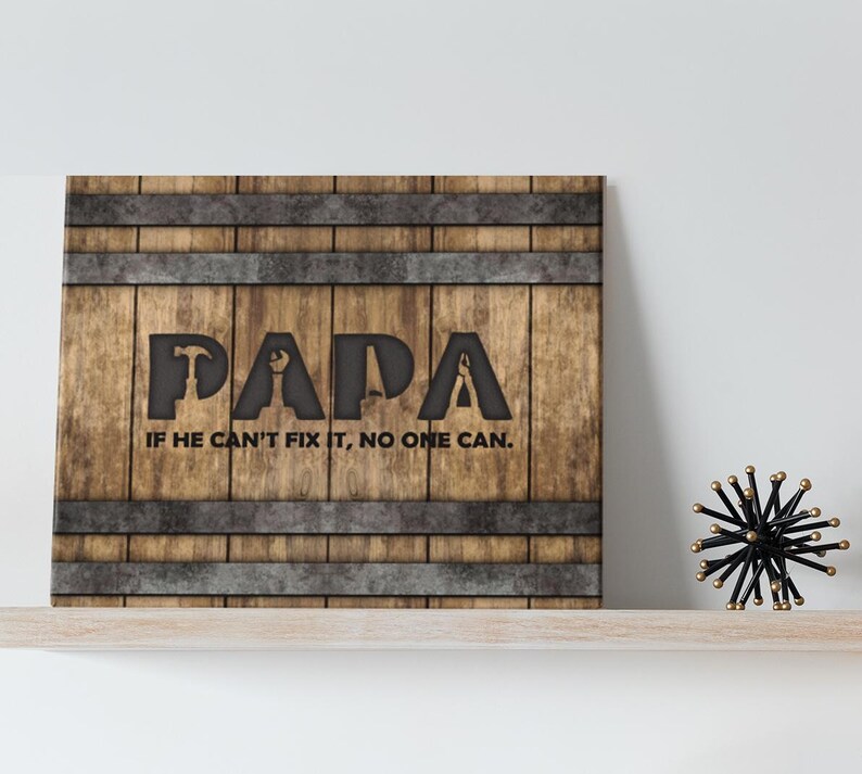 Each letter in the bold word PAPA includes the silhouette of a hand tool as part of the letter.  Beneath the word PAPA is the phrase “If he can’t fix it, no one can.” The background looks like aged vertical boards similar to a flattened oak barrel. At the top and bottom are aged metal strips. This is a perfect gift for anyone’s husband, dad, stepdad, grandpa, or favorite male friend who has tools and knows who to fix things. NOTE: This is a flat metal sign, not real wood or metal.
